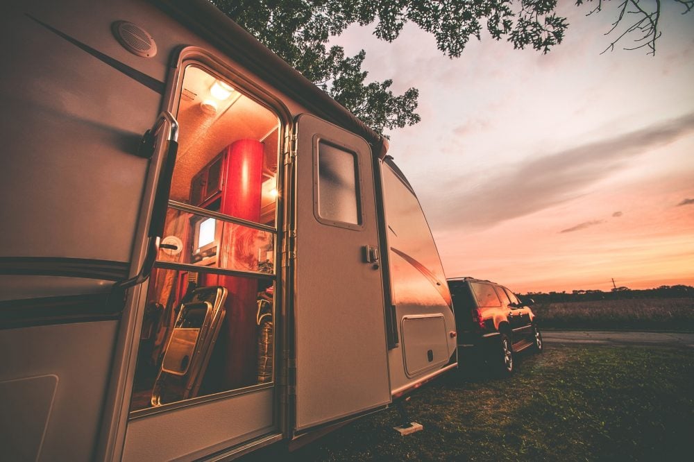 Camper parked at a campsite at sunset