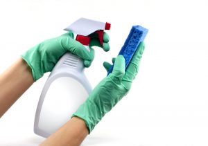 Hand with cleaning gloves spraying mattress cleaner solution