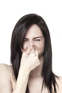 Woman pinching nose due to bad mattress odor smell