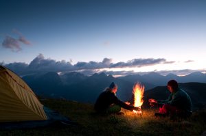 Tent camping with campfire at sunset