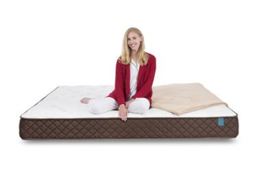 Woman sitting on pocketed coil mattress